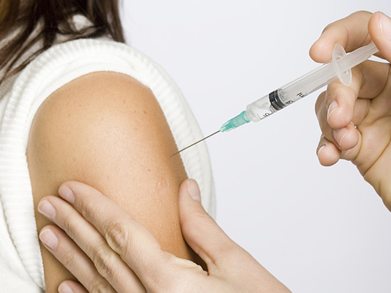 Healthcare professional applying cotton pad on patient’s arm